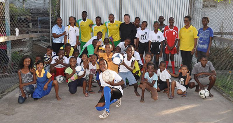 GFF TD, Claude Bolton, Golden Jaguars Chris Nurse, Daniel Wilson and Vurlon Mills along with NC Member Dr. Karen Pilgrim and RCAC VP Ms Ismay Murray pose with the children after the session.