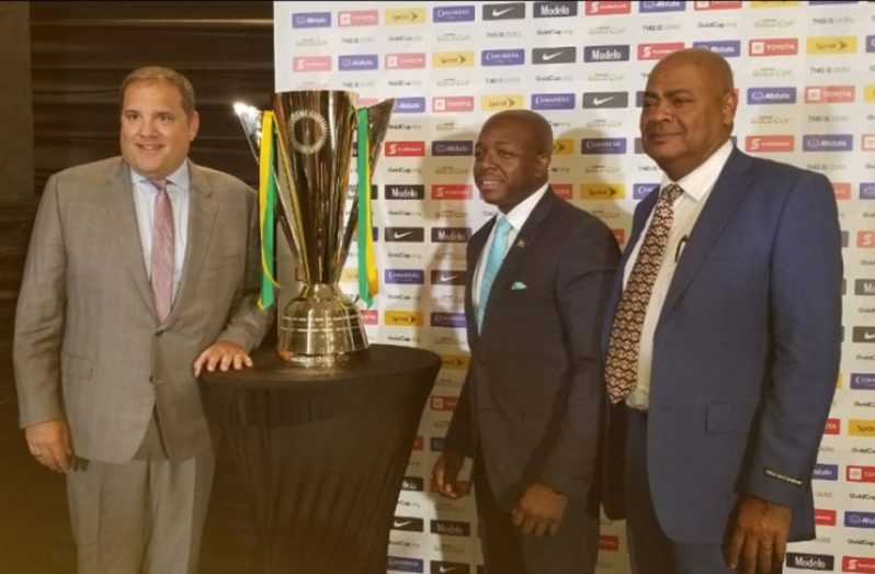 CONCACAF president Victor Montagliani (left) poses with the Gold Cup after announcing that Jamaica will be hosting two games inside the National Stadium on June 17. Sharing in the historic occasion at the Jamaica Pegasus Hotel are JFF president Michael Ricketts (right) and Senator Pearnel Charles Jr, who represented Minister of Sports Olivia Grange. (Jamaica Observer photo)