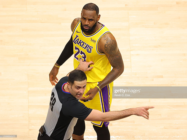 NBA official Mousa Dagher #28 looks over at a fan courtside as he stands in front of LeBron James #23 of Los Angeles Lakers during the incident. (Photo by Kevin C. Cox/Getty Images)