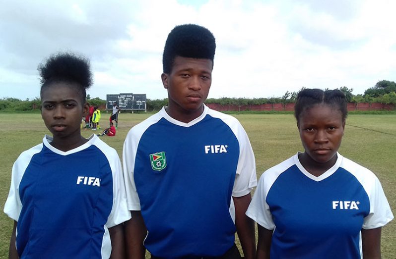 New referees Janelle Peters (left), Abraham Chester and Ashanti Smith pose just before their first officiating stint at the Anna Regina Community Centre ground.