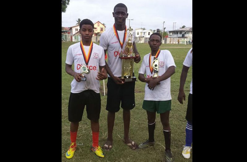 Jermaine King (centre) poses with teamamates after the Digicel Schools football victory