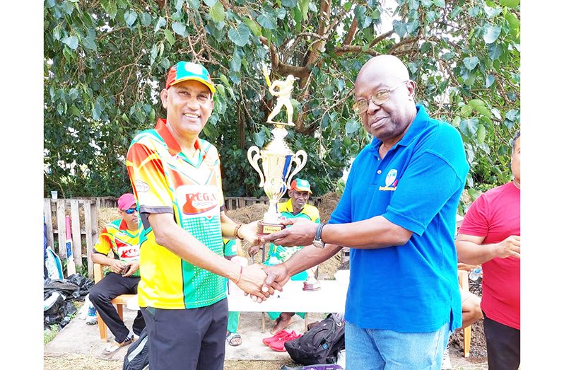 Regal Legends captain and man-of-the-match, Mahendra Hardyal collects the winning trophy from Georgetown Softball Cricket League (GSCL) President Ian John