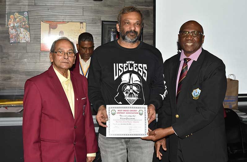 Umpire Kiran Suraneni, flanked by CCUA President Azad Khan, left and WICUA President Johnson, poses with his WICUA Certificate