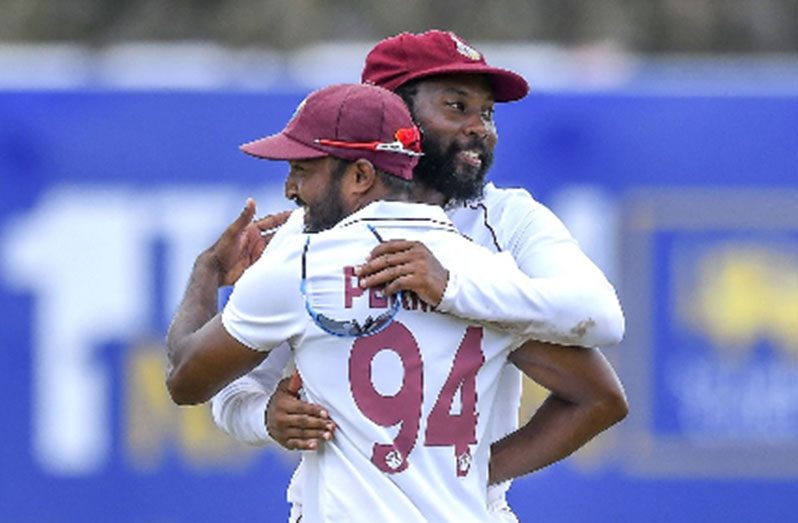 SPIN TWIN: Veerasammy Permaul (94) is embraced by Jomel Warrican after claiming his maiden five-wicket haul in Tests