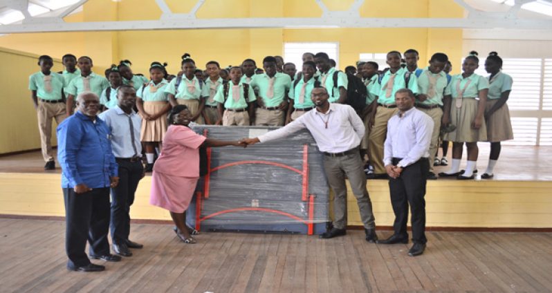 (L-R) Administrative Officer of the NSC, Gervy Harry, watches as Lodge Secondary School teacher Leon Bishop and Headmistress Beverly Cyrus collect the tennis table from Director of Sport Christopher Jones and GTTA president Godfrey Munroe. (Samuel Maughn photos)