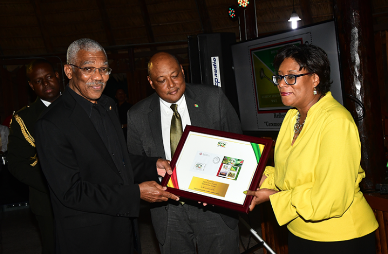 President David Granger receiving the commemorative stamps from Minister of Natural Resources Raphael Trotman and Minister of Public Telecommunications, Catherine Hughes