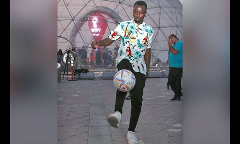 A man juggles a football near the dome which houses the Qatar 2022 FIFA World Cup countdown clock, in the capital Doha on Friday. (Photo: AFP)