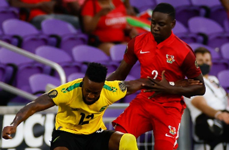 Goal-scorer Junior Flemmings holds off Guadeloupe’s Kevin Moeson during the Group C game.