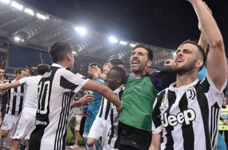 The Juventus players celebrate after their draw in Rome confirmed a 34th top-flight title