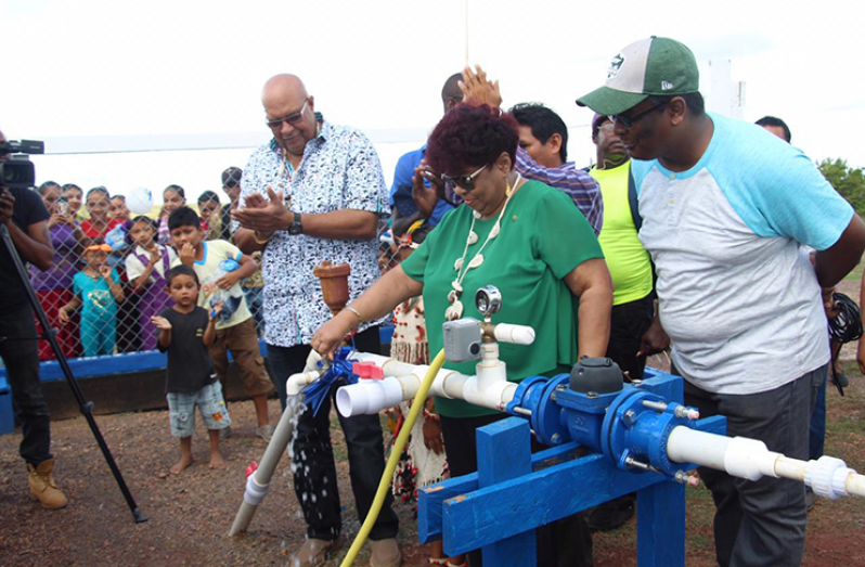 Minister of Social Protection, Amna Ally, removes the ribbon to officially commission the solar-powered water-supply system in Kaicumbay, Central Rupununi. To her left (applauding) Managing-Director of Guyana Water Incorporated Dr Richard Van-West Charles and (extreme right) Region Three Regional Information Officer Ganesh Mahipaul