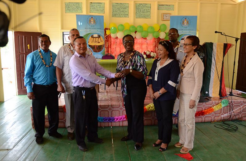 Minister of Education Nicolette Henry, handing over the key to the school’s Head teacher, Alex Crammer
