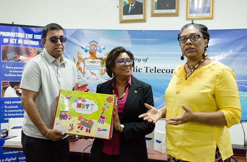 Co-founder of STEM Guyana, Karen Abrams, underscores the importance of providing equitable access to all Guyanese
in the ICT sector as Minister of Public Telecommunications, Catherine Hughes, presents Programme Coordinator of
Guyana Council of Organisations for Persons with Disabilities, Ganesh Singh, with a robotic set on