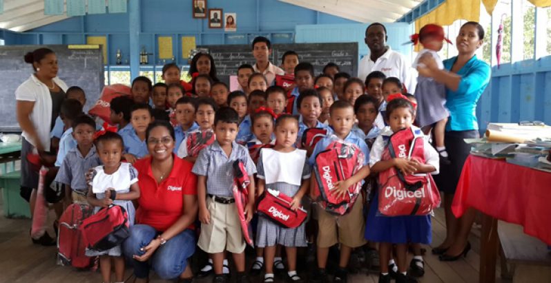 Students of Karrau Creek Primary and Nursery Schools with their tokens with teachers and Digicel Guyana officials Tuesday (Photo my Michel Outridge)