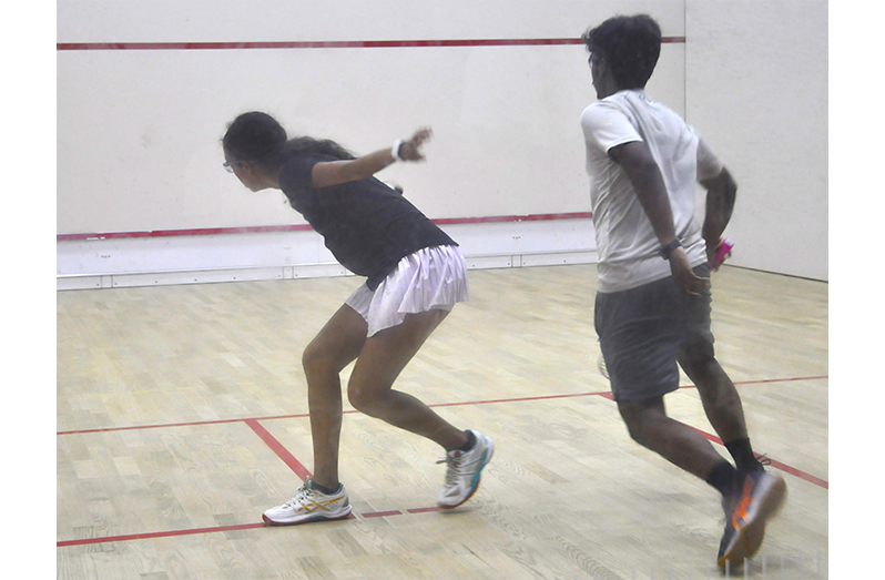 Kaylee Lowe (left) play a backhand shot in her 3-1 win over Justin Goberdhan (Sean Devers photos)