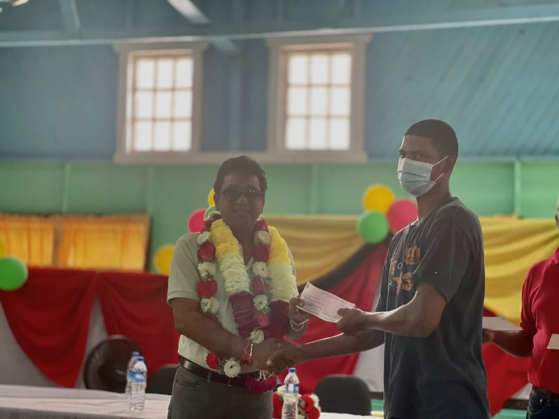 Kenneth Arthur, a rice farmer of Region Six (East Berbice-Corentyne) receives his flood-relief in the form of a cheque from Attorney General, Anil Nandlall, SC, at Friends Primary School in Sisters Village on Sunday (Richard Bhainie photo)