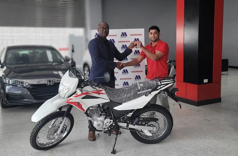 GFF head Wayne Forde (right) receives the keys from the Honda motorcycle from Khemraj Jaikaran of Marics and Company Limited