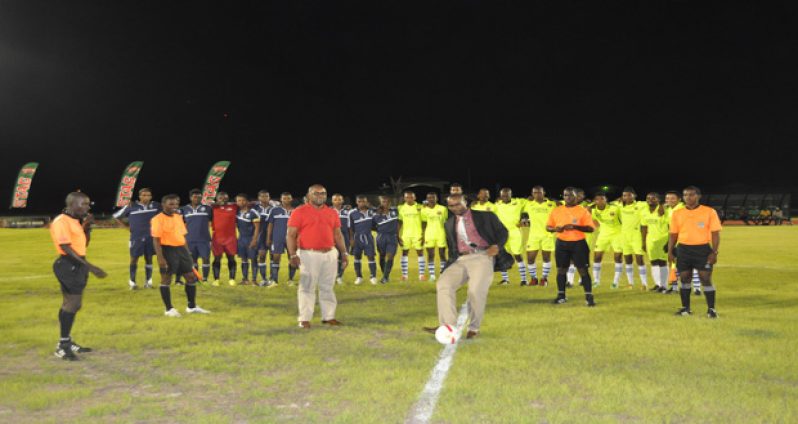 GFF president Wayne Forde performs the ceremonial kick-off, while second vice-president Rawlston Adams looks on.