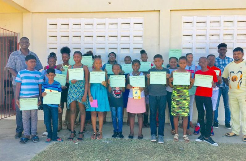 Some of the camp attendees with their certificates and Regional Culture and Youth Director Omeshwar Sirikishun (right) and Chairman of the Bush Lot-Adventure NDC Colin Moore (left)