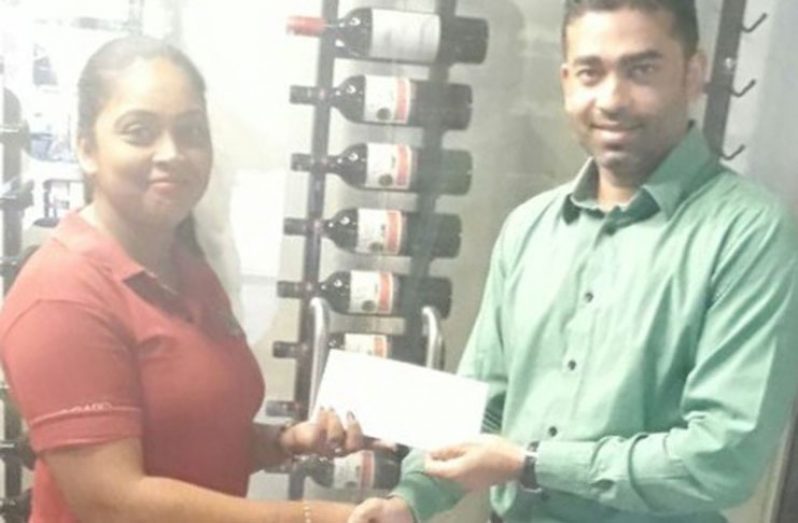 Ralph Persaud (right) hands over his sponsorship cheque to Tina Morris of GMR&SC for the International Race of Champions 2017.