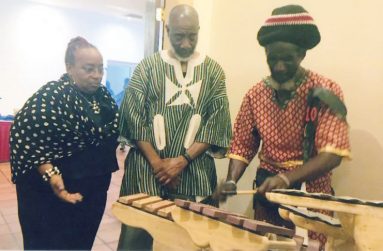Jones outlines the make-up of his musical instruments for patrons: Dr. Dawne Stewart and Dr. Washington at a recent cocktail function in Georgetown.