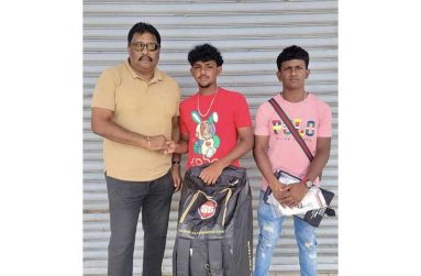 Koobeer and Mohamed pose with their tokens, along with Anil Beharry..