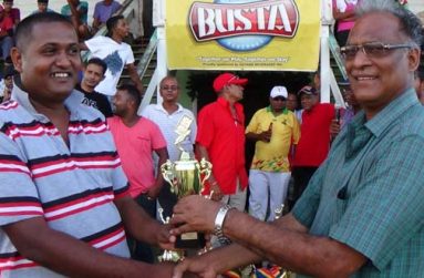 Director of Sport Neil Kumar (right) hands over the trophy, that was up for grabs for the dominoes competition, to the captain of the victorious Enterprise Shop team.