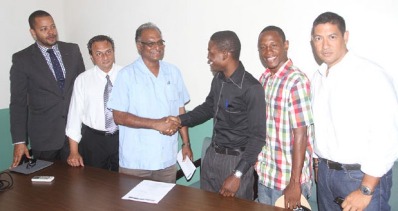 Congratulations, and make Guyana proud! This must be the message from Director of Sport Neil Kumar (3rd from left) as he shakes the hand of Clive Atwell. From left: Ronald Burch-Smith, Peter Abdool, Leon Moore and Andrew Arjoon look on. (Photo by Sonell Nelson)