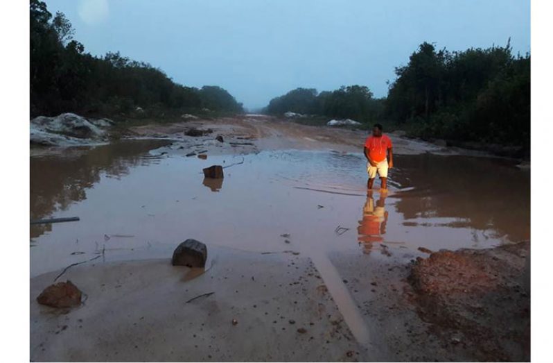 In this photo, which was taken on Saturday morning, a driver--Jason Sampson, who plies the route on a daily basis walks into a large pool of water to determine the best part to drive