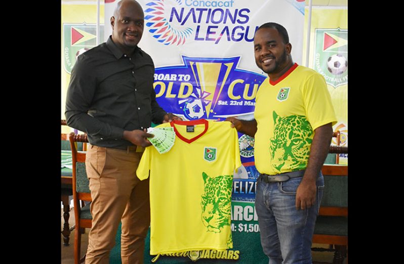Let’s Bet Sports Brand Ambassador, Rawle Toney (left), presents the jerseys and tickets to GFF’s Social Media Officer Williams.
