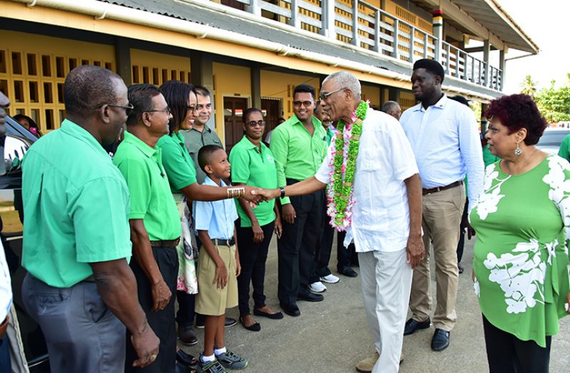 President David Granger on arrival at the Corriverton Primary School greets representatives of the PNCR. Also in photo is Minister of Social Protection, Ms. Amna Ally (right).