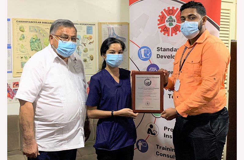 GNBS Technical Officer, Latchman Mootoosammy, on April 20, 2021, handed over a plaque to the Medical Director of the Diagnostic Centre, Dr. Leslie I.R. Persaud and the laboratory’s Quality Manager, Tereasia Ramlochan