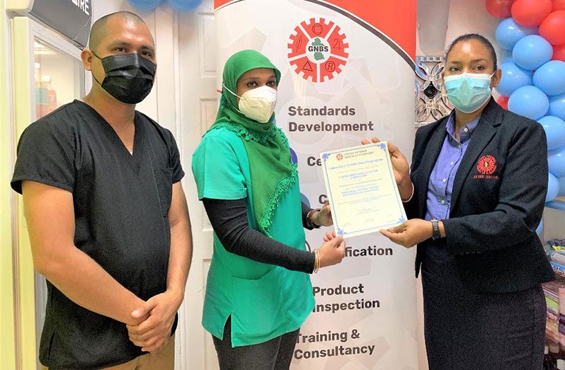 Head of the GNBS’ Certification Services Department, Andrea Mendonca, hands over the certificate to General Manager, Bibi Nafeeza Bacchus