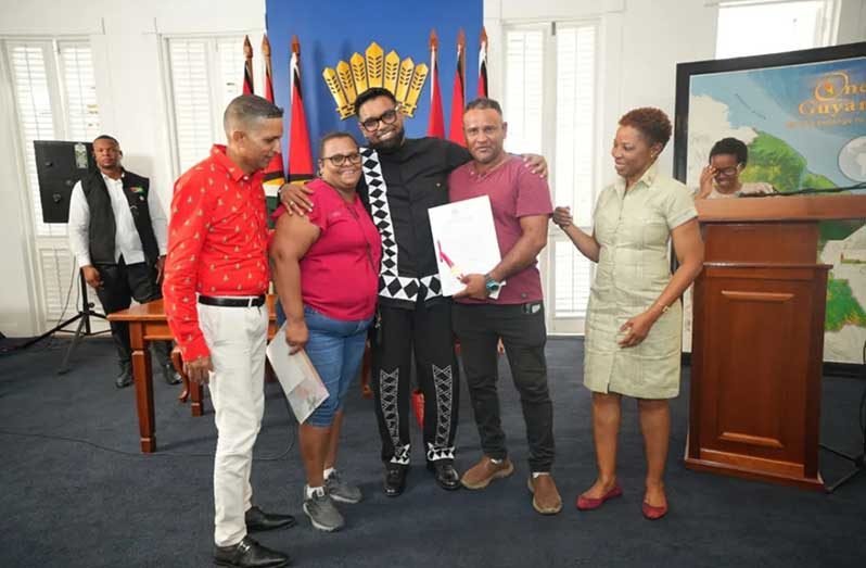 President Irfaan Ali and ministers share a light moment with some of the recipients