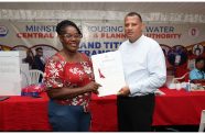 Minister of Housing and Water Collin Croal presents a land title to a recipient