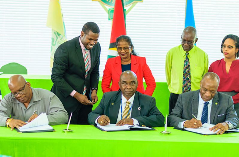 Minister of Finance Winston Jordan; FAO Country Representative, Reuben Robertson; and Minister of State, Joseph Harmon, signing the Sustainable Land Development and Management Project document at State House.