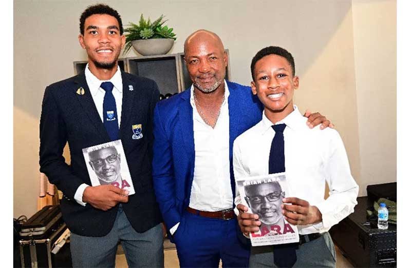 INSPIRATION TO GENERATION Z: West Indies cricket legend Brian Lara presents copies of his book, Lara: The England Chronicles to Fatima College students, Liam Golding (Upper Six head prefect), left, and Johann Fournillier (Form Two), both of whom were invited to read excerpts, during the local launch at Lara’s home on Lady Chancellor Hill. —Photo: JERMAINE CRUICKSHANK (Trinidad Express)