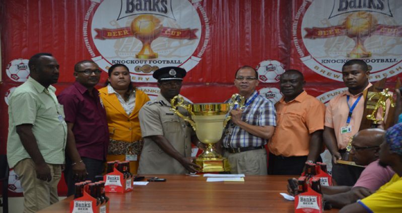 GFA president Clifton Hicken collects the winner trophy from Banks Beer Brand manager Brian Choo-hen in the presence of other GFA Executives. (Delano Williams Photo)