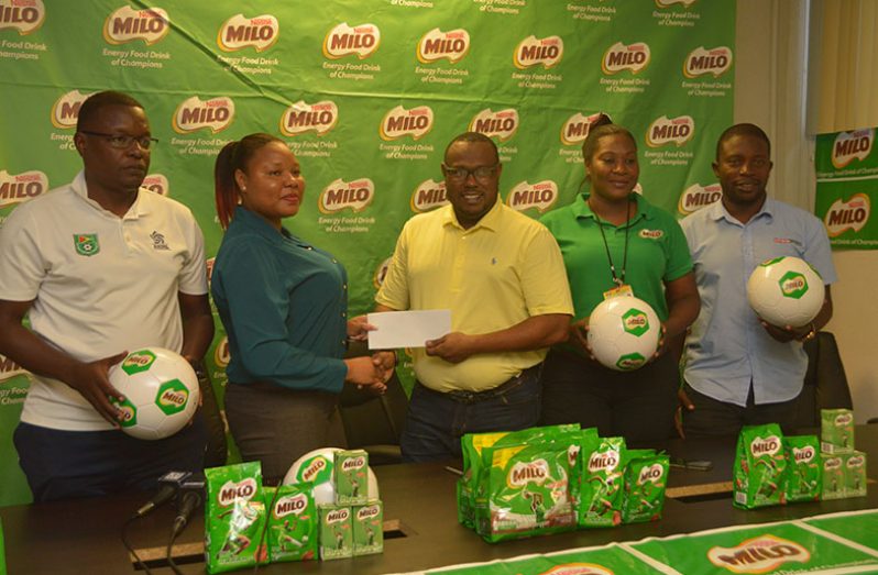 GFF technical officer Bryan Joseph (left) watches as Milo Brand manager Shellona David hands over sponsorship to Petra co-director Troy Mendonca. Jacquline Boodie and Sean Embrack of Petra look on. (Adrian Narine photo)