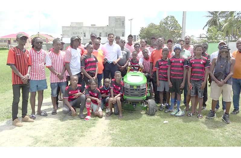 Minister of Sport Charles Ramson Jr, Assistant Director of Sport Franklyn Wilson, Camptown FC president Selwyn Robertson  with club officials and players at Saturday’s handing over of the lawnmower.