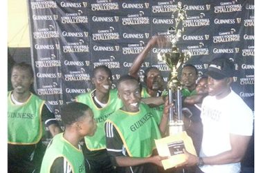 Yes, we are the champions! An ecstatic Joshua Browne, captain of the victorious North Ruimveldt team, smiles broadly as he collects the first place trophy and cash prize from Banks DIH’s Guinness Brand Manager Lee Baptiste, while his teammates share the moment gleefully.
