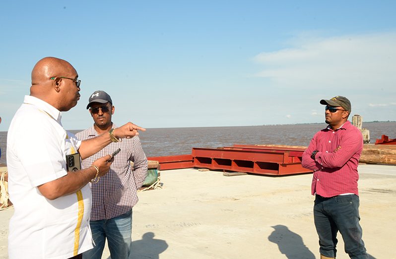Minister of Public Works, Juan Edghill speaks to the contractor, Sattrohan Maraj (right)