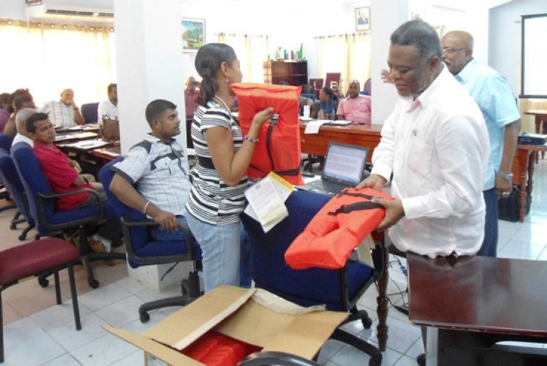 Prime Minister Samuel Hinds examines one of the life jackets to be distributed