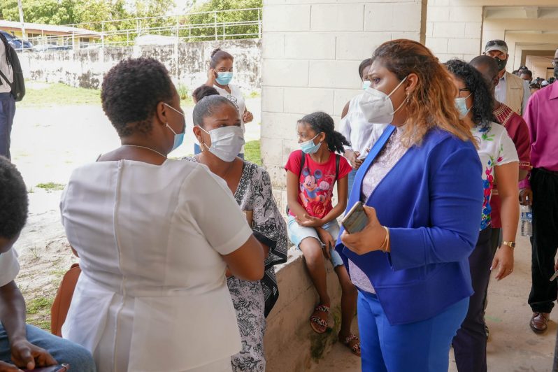 Minister of Education, Priya Manickchand interacting with parents at the ‘Because We Care’ distribution exercise at the Christiansburg-Wismar Secondary School on Thursday (Ministry of Education photos)