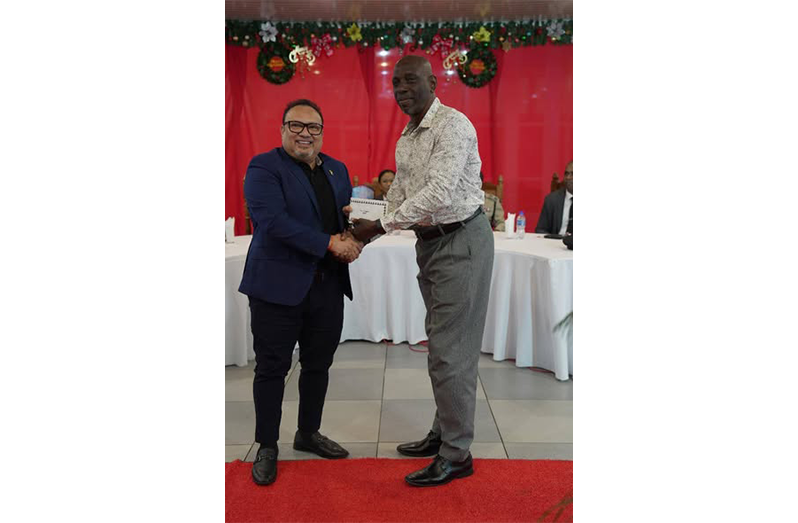 Linden Matthews (left), receives his award from Guyana Cricket Board president, Bissondial Singh