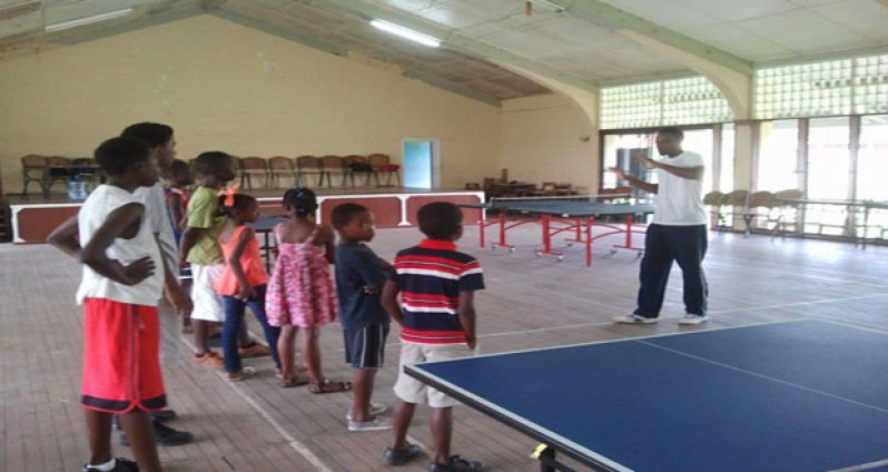 Coach Shavin Greene demonstrates a fundamental element to young students.