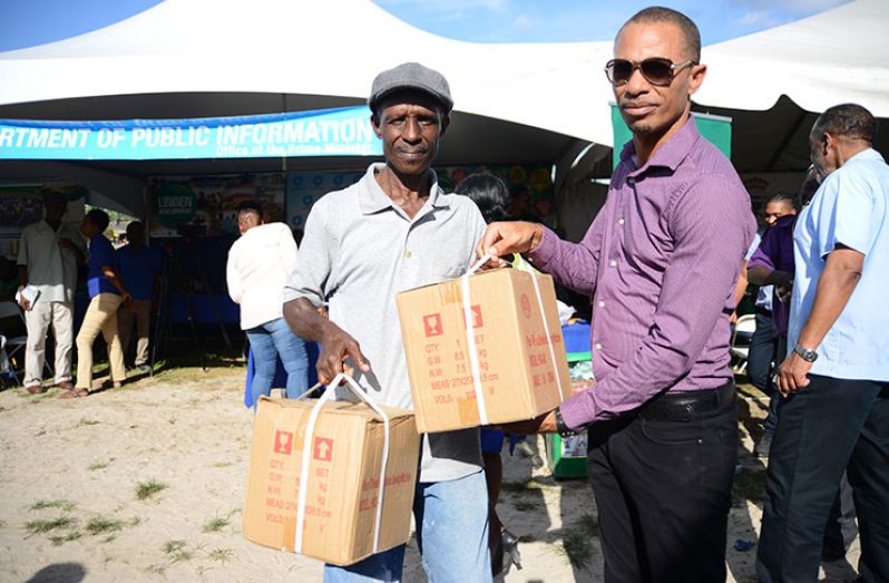 APNU Campaign Member Damuka Ngqondo (right) hands over two sewing machines to Godfrey Day on behalf of the Ministry of Social Protection (Samuel Maughn photo)