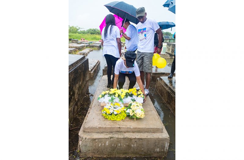 Dax Arokium’s mother, Jacklyn Arokium, laying a wreath on the third tomb, in which it is said the remains of her son and five other miners had been placed.