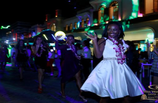 A beaming Lisa Punch waves to the large crowds as she and the other delegates head to the welcome ceremony held in their honour