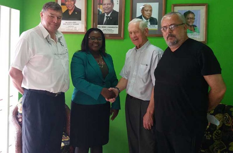 Minister within the Ministry of Natural Resources, Simona Broomes, shaking hands with Greenpower Energy Executive Chairman Gerard King, in the presence of AEFS Consultant to Greenpower Energy John Watts (left) and Leandro Pires of Guyana Strategic Metals (right).