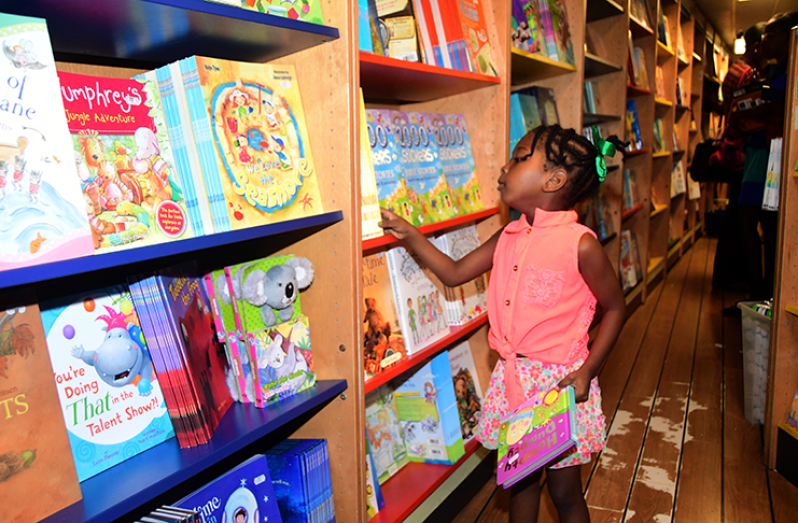 Persons aboard the Logos Hope browsing through its immense book collection  (Adrian Narine photo)